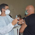 Agente penitenciário recebendo dose de vacina contra a covid-19